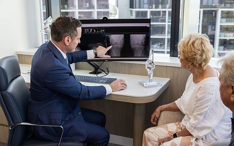Professor Rodda reviewing a knee X-ray with a patient
